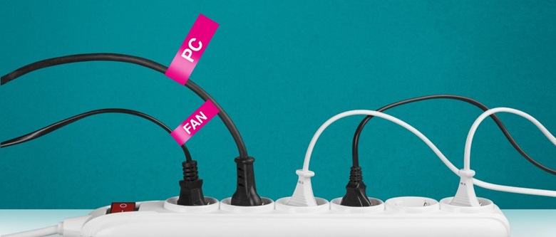 An einer Mehrfachsteckdose sind drei schwarze und zwei weiße Stecker eingesteckt. 
