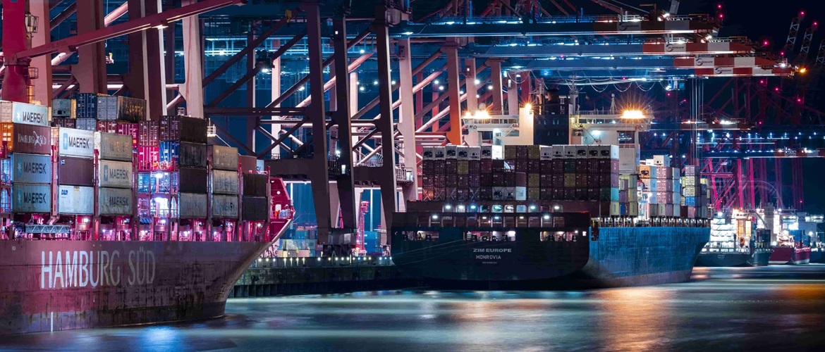 Zwei Frachtschiffe, die an einem Containerterminal liegen. 