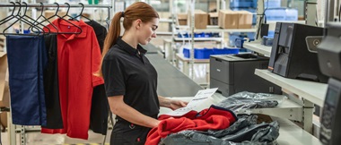 Eine Frau betrachtet im Kontext der Retourenabwicklung einen Lieferschein.