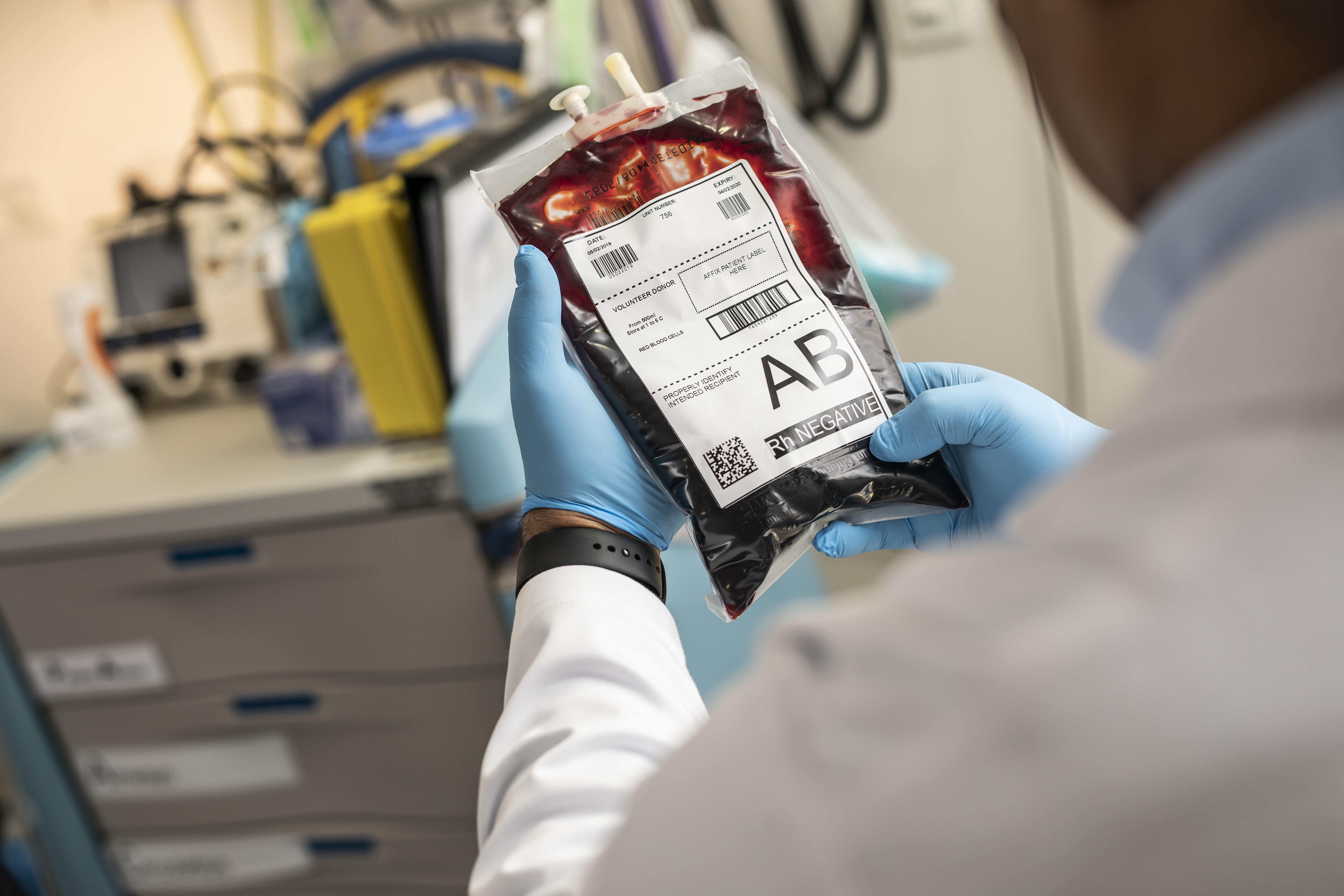 Ein Arzt hält eine gelabelte Blutkonserve zur Bluttransfusion in der Hand