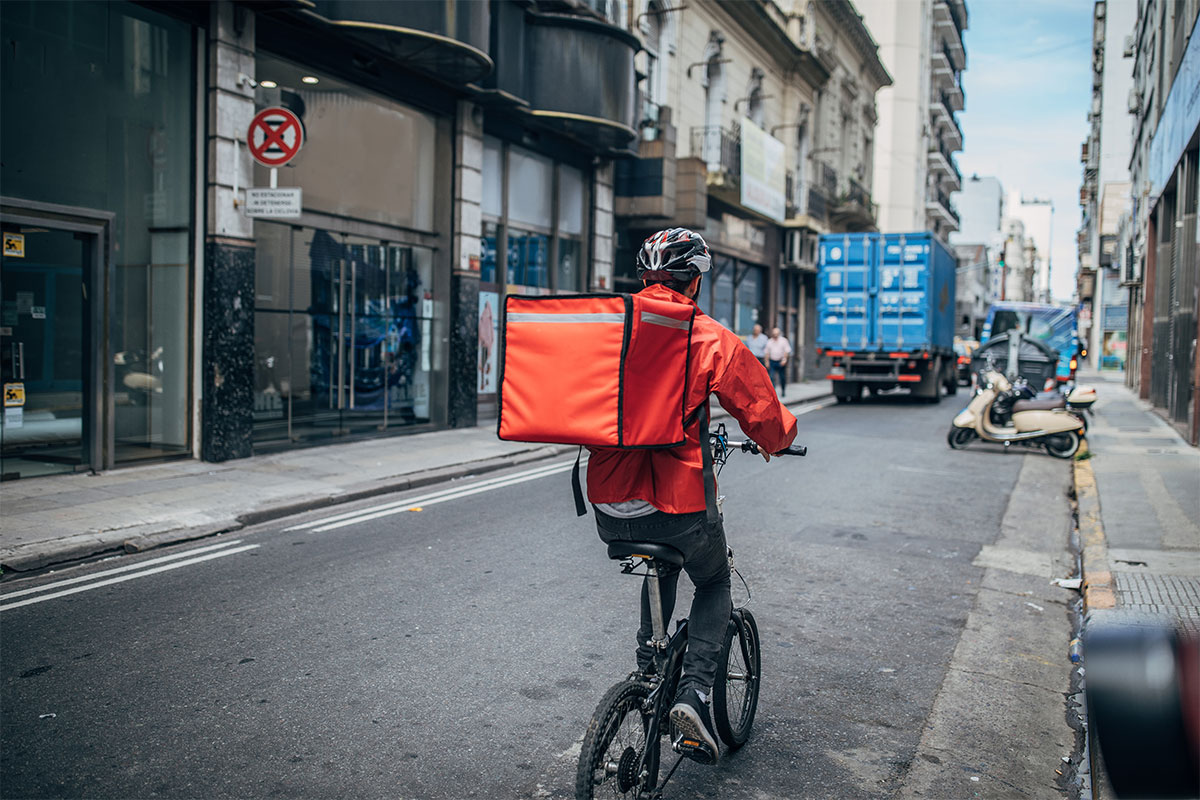 Ein Fahrradkurier fährt auf der Straße.