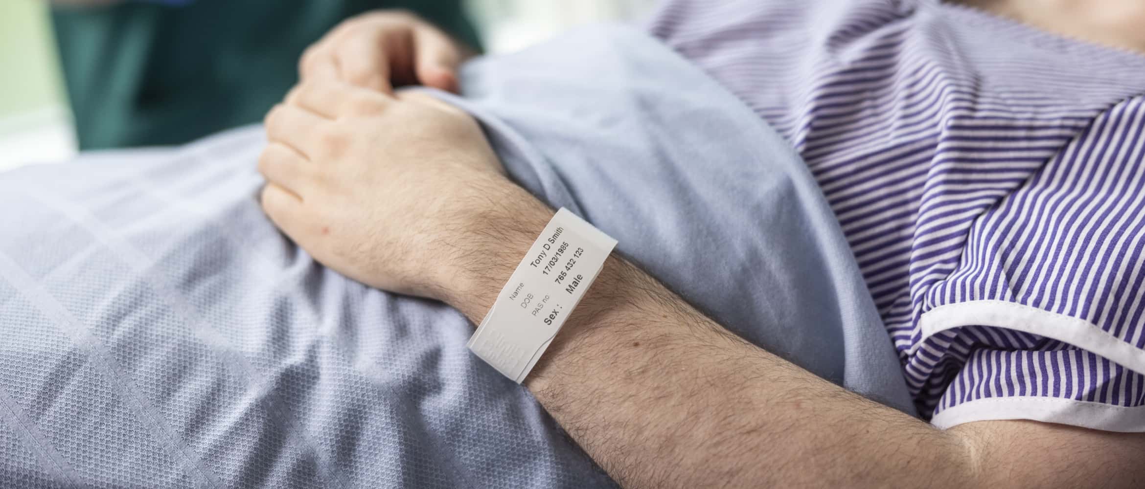 Eine Person mit einem Patientenarmband.