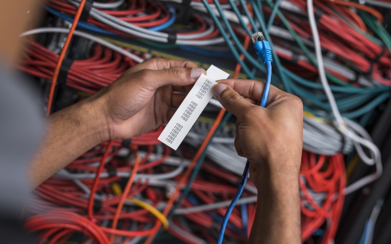  Eine Person, die Kabel mit einem Etikett versieht.