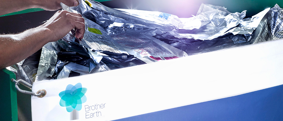 Person sortiert leere Tintenpatronen und Tonerkartuschen in Recycling-Behälter.