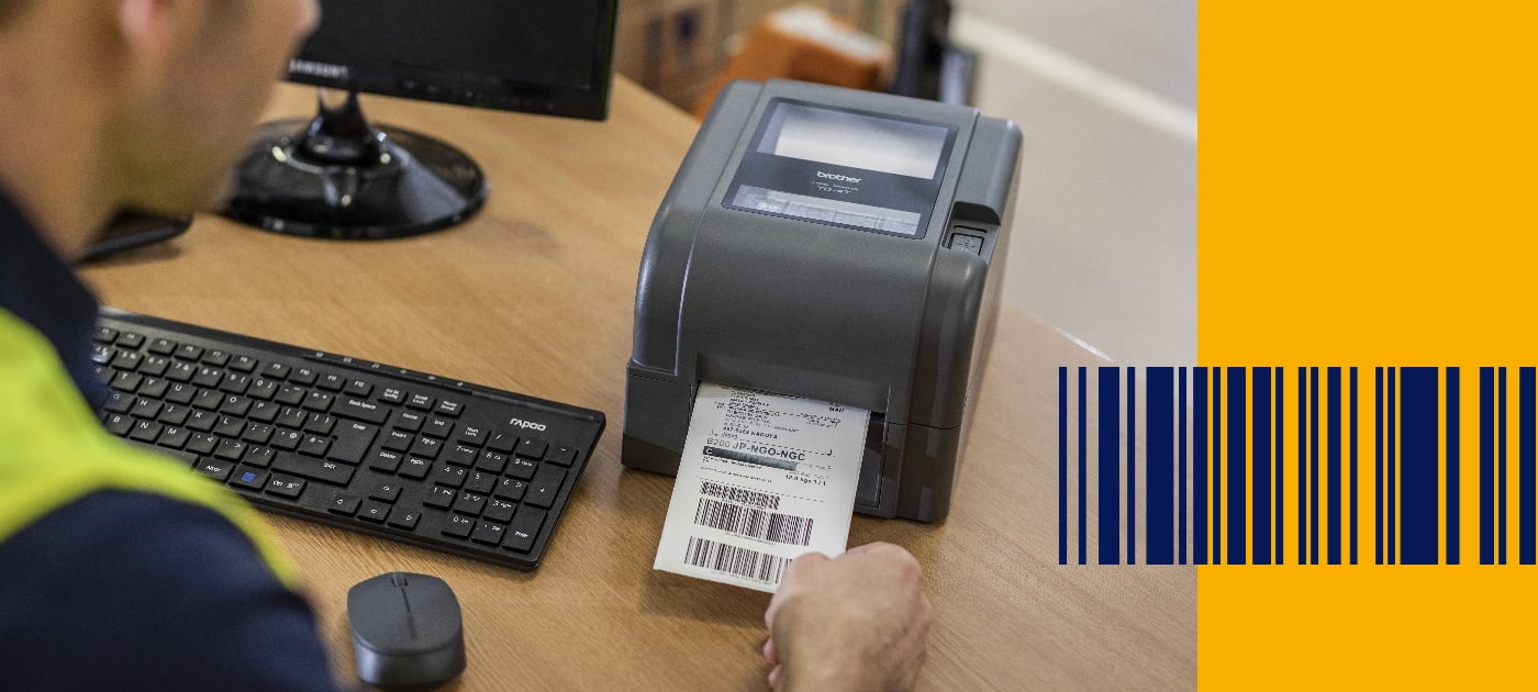 Ein Lagerarbeiter, der eine Warnweste trägt, entfernt ein Barcode-Etikett aus einem Brother TD-Etikettendrucker 