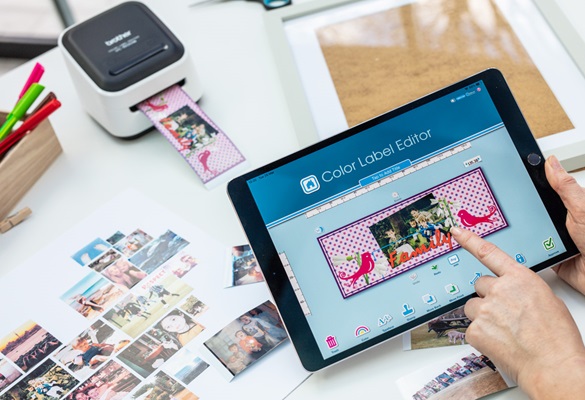 Crafter, der ein vollfarbiges Etikett auf ihrem Tablet entwirft, dann drucken Sie auf den Drucker des Brother-Designs und des Bastelaufklebers