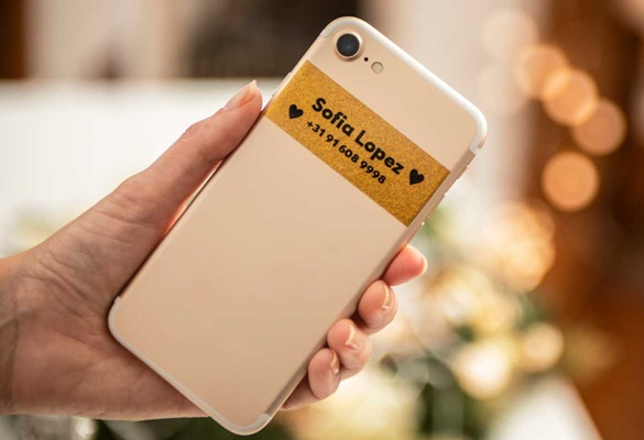 Schwarz auf Premium Gold Glitter-Label auf Smartphone mit Name und Kontaktnummer des Eigentümers